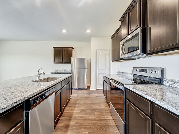 Enjoy stunning granite countertops and designer wood cabinetry in this kitchen.