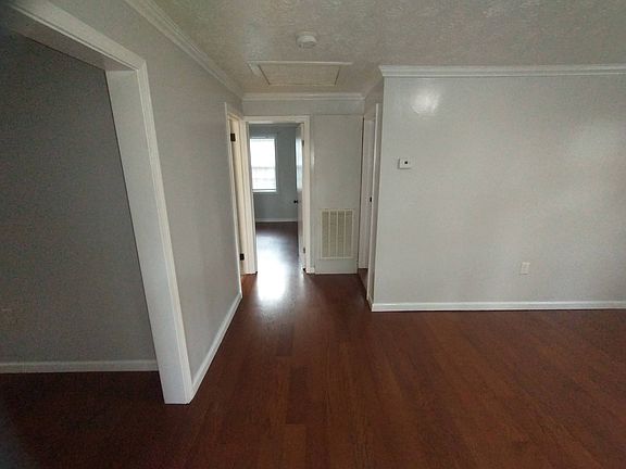 living room view into bedroom, laundry off left, off right additional bedroom, off left before bedroom is bathroom