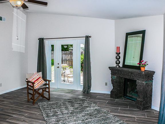 This charming living area has a beautiful wood burning fireplace with rock mantel and glass doors overlooking the patio and fenced back yard.