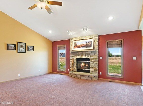 Beautiful gas log fireplace with stone surround with full length windows on each side!