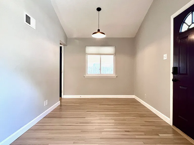 Dining room with dimmable overhead lighting and cellular privacy shades.