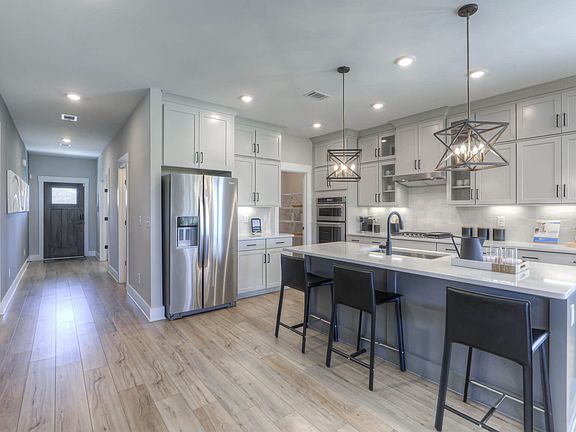 Prep dinner in the kitchen while entertaining guests.