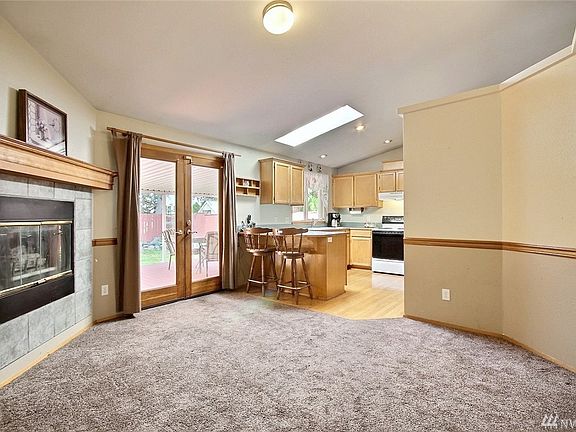 Family room with cozy gas fireplace is fully open to generous, light-filled kitchen overlooking your private backyard. Note the beautiful French doors leading to the expansive covered deck.