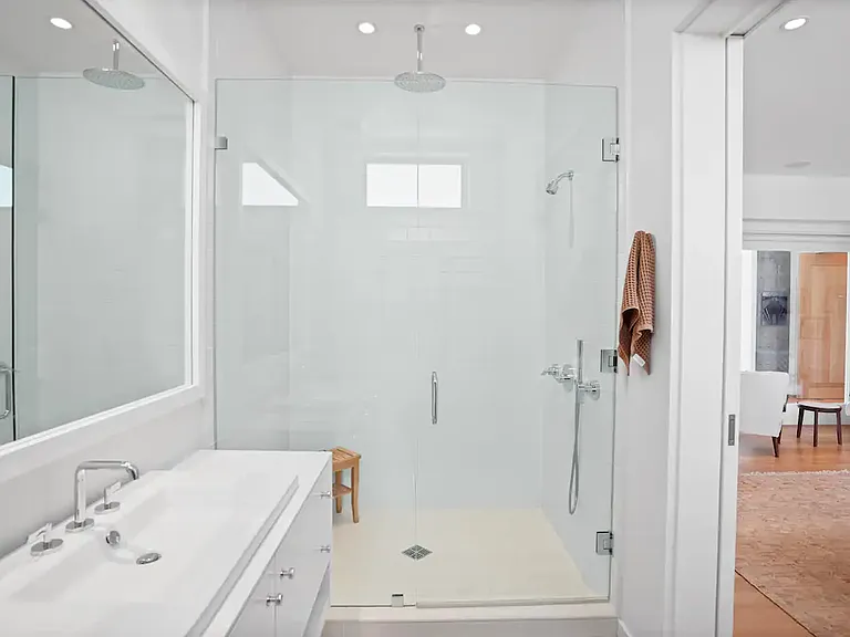 Features a generous walk-in shower with a modern rain showerhead.