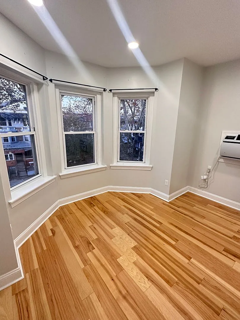 1-bedroom with a bay window and refinished hardwood — Photo 3