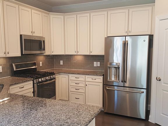 Beautiful white kitchen with all stainless steel appliances,