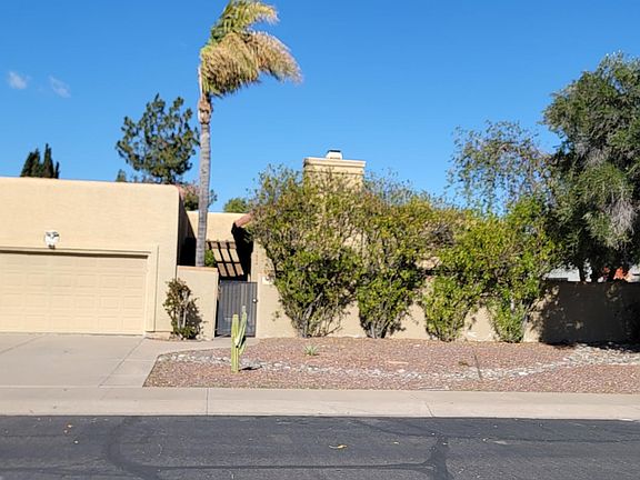 Old exterior photo. House is now white. Palm tree has been removed.