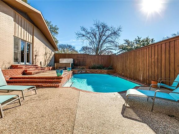 Doors on the left are the Master bedroom with brick stairs coming down into the pool. Far left is a separate hot tub. Board-0n-Board privacy fence.