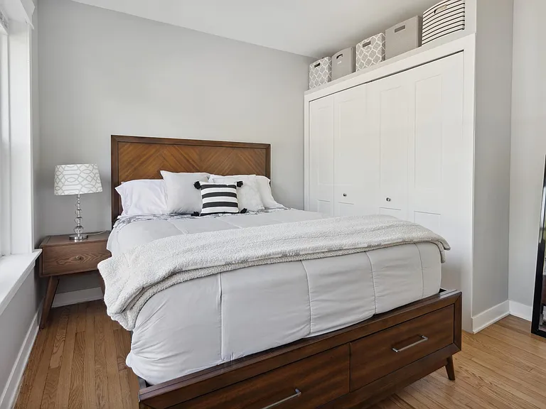 Bedroom with built in closet and additional storage space above closet