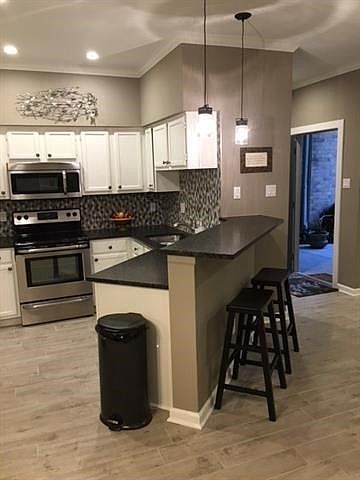 Kitchen with Breakfast bar features granite and stainless appliances.. Under cabinet lighting and walk in pantry.