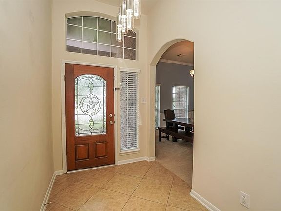 Enter home with wide neutral tile laid on the diagonal and updated entry light.