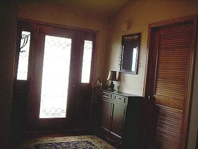 foyer has hard wood floors and leaded glass doors