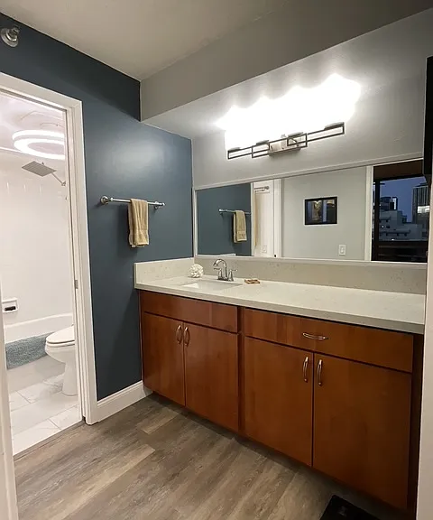 large vanity cabinet, smart light above vanity, bedroom across vanity as seen in mirror