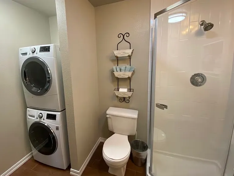 hallway bath with stacked full size laundry