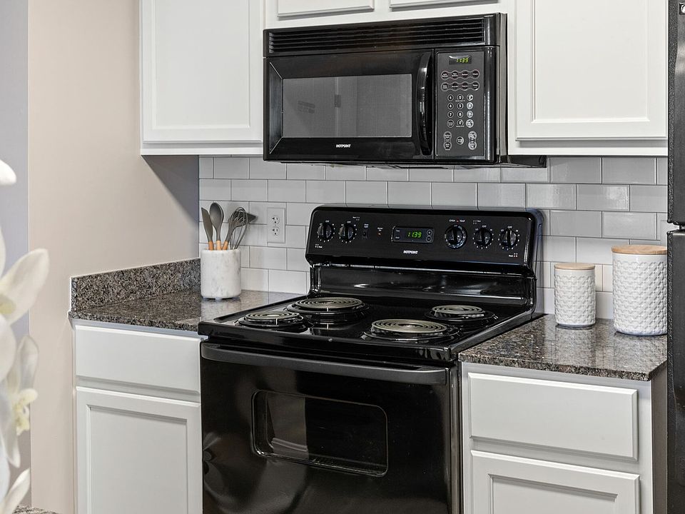 Cook with ease in a fully equipped kitchen featuring modern black appliances and granite countertops