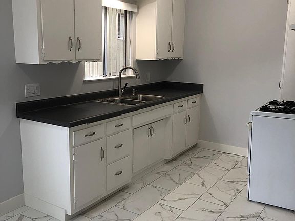 New kitchen counter, sink, tile flooring.