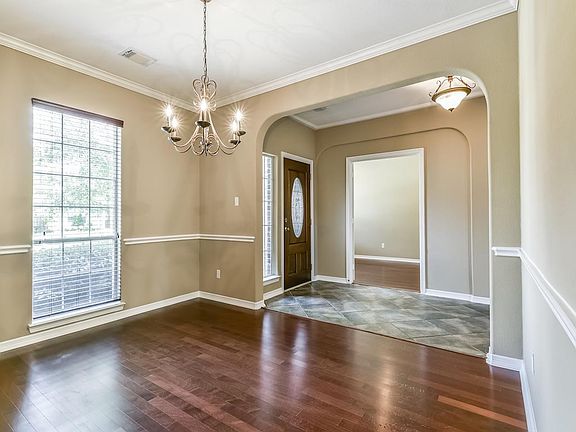 Formal Dining Room with Chair and Crown Mouldings, view towards the Entry and formal Living room. The home has been freshly painted and shows like new.