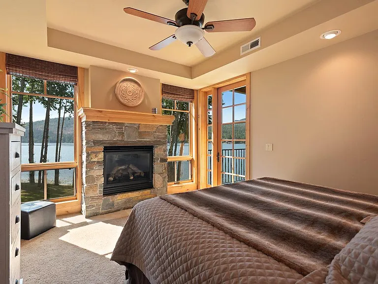 Cozy master bedroom with warming fireplace, SE water views, deck