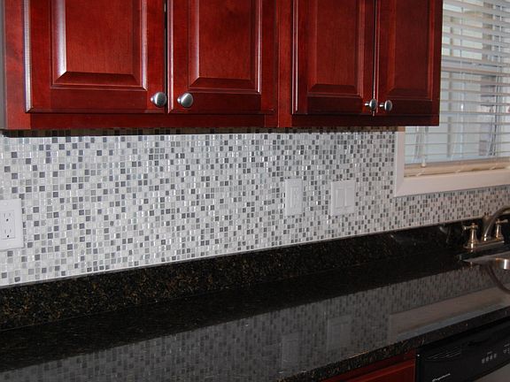 Galley kitchen overlooks courtyard. New glass-mosaic backsp
