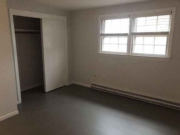 Sunny large bedroom with painted hardwood floor