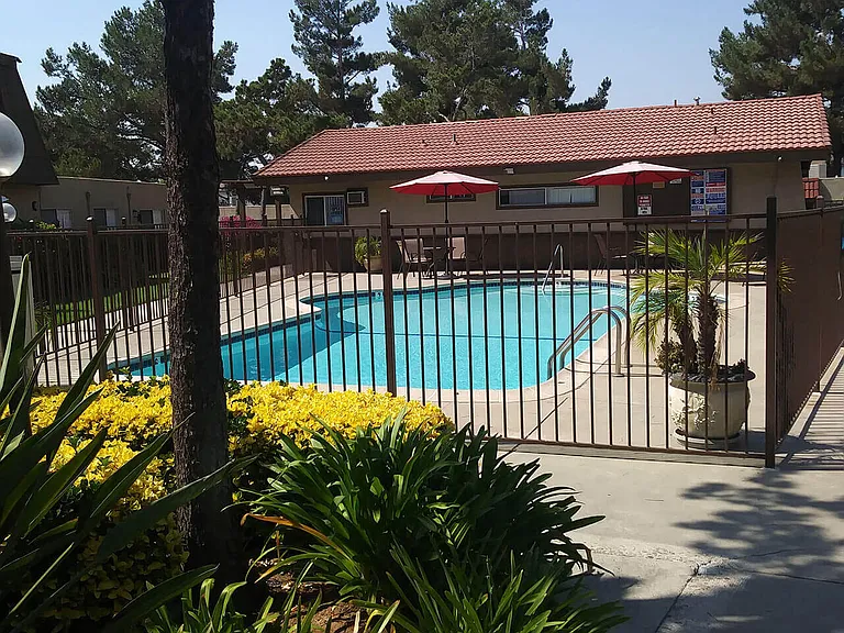 Swimming pool and sun deck at Teton Pines Apartments in Escondido, California.
