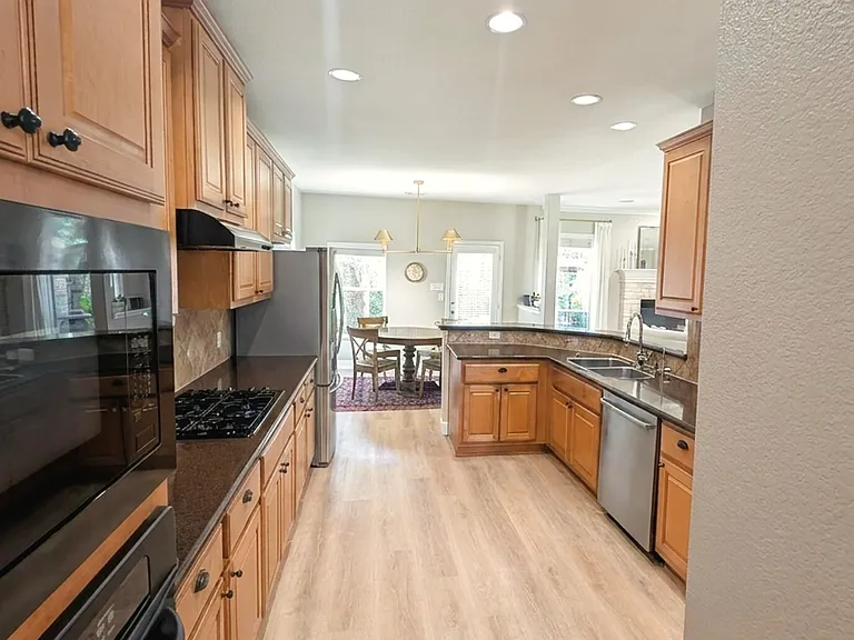 Kitchen with granite counters, maple cabinetry, and stainless appliances