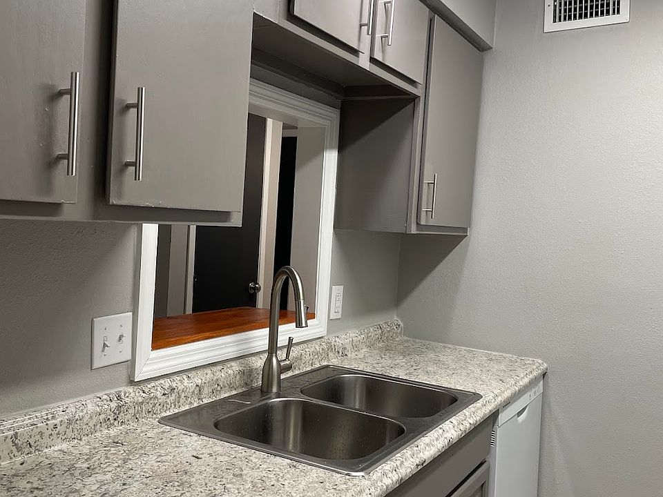Kitchen features a window connecting it to the living room, plenty of cabinets, a deep sink and high-arch faucet.