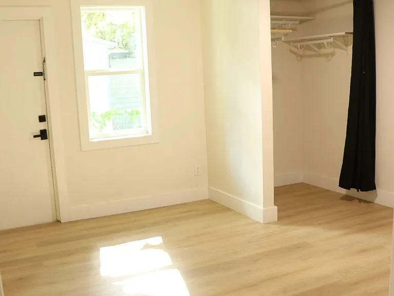 Cozy bedroom with natural light, perfect for guests or office space.
