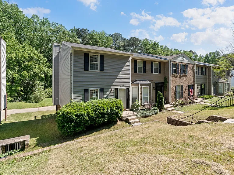 Desirable end/corner unit offering extra privacy and natural light, nestled against a wooded backdrop