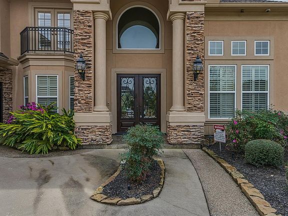 The magnificent custom Bob Hale home has an impressive entry, stacked stone elevation, double iron and wood doors.