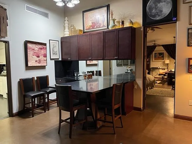Black quartz wet bar/peninsula. Bedroom and office in rear.