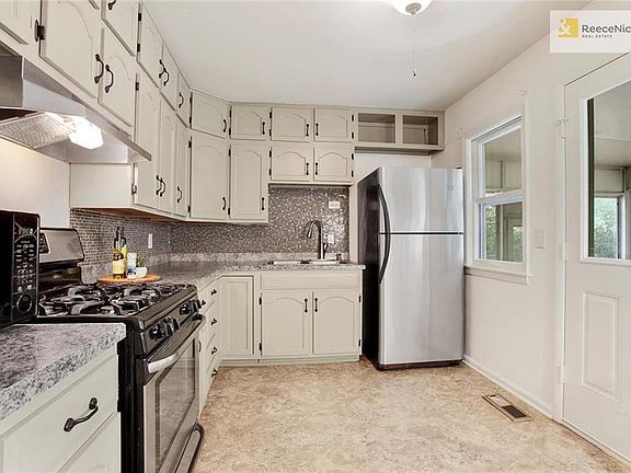 CABINETS GALORE! Lovely backsplash, New sink and faucet, gas stove, microwave and refrigerator stay!