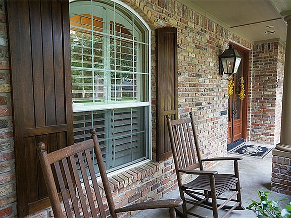 Inviting covered front porch with beautiful double wood doors.