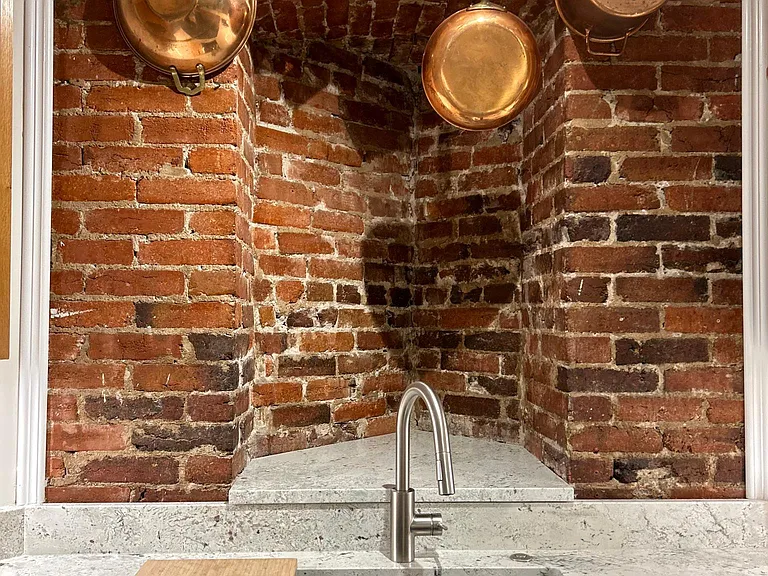 Underhung stainless steel sink with cutting board and roll-up drain rack.