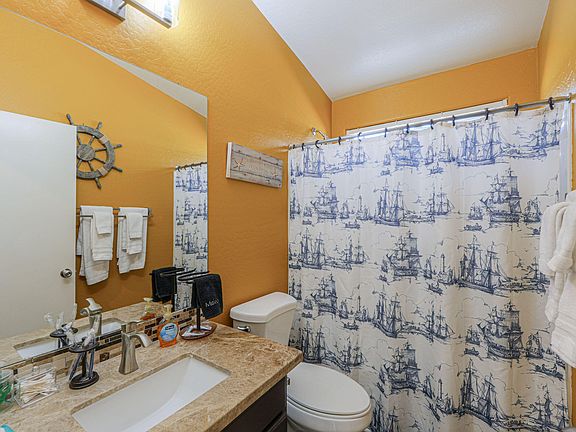 Full bathroom with a single-sink vanity, ample counter space, towel storage, and a tub/shower combo.