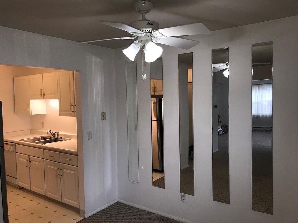 Cosy galley kitchen, newer stainless steel fridge opens to dining room.