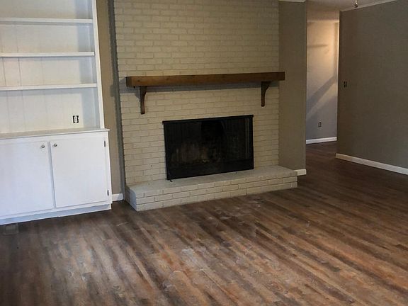 Den with wood burning fireplace and built in bookcase