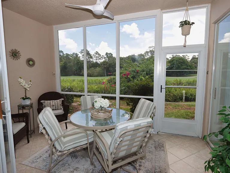 Back enclosed lanai overlooks the golf course and features an additional dining space w/four chairs, as well as two comfy wicker chairs to accommodate more guests. This space can be opened up to the living area by opening the sliding stacker doors.