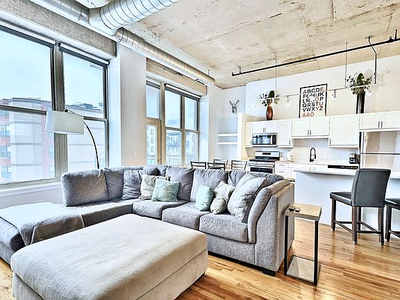 Large windows, open layout, tons of natural light, large living area with sectional couch