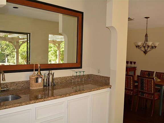 Wet bar has a nice clean look with fresh paint. Opens to the formal dining room and living room for easy entertaining. Sliding glass doors takes you to the back patio and pool.