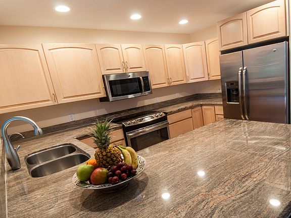 kitchen counter has 2 bar stools as well for dining on spacious counter
