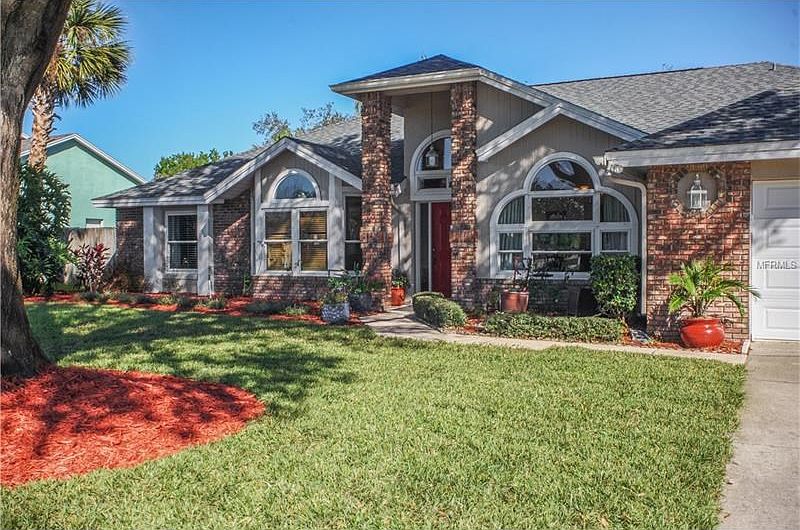 Welcoming entrance and two car garage with lush landscaping.