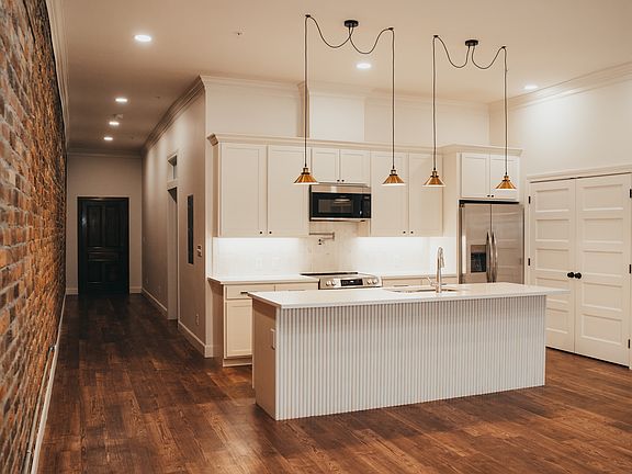 Kitchen with island looking down the hallway towards the front door.