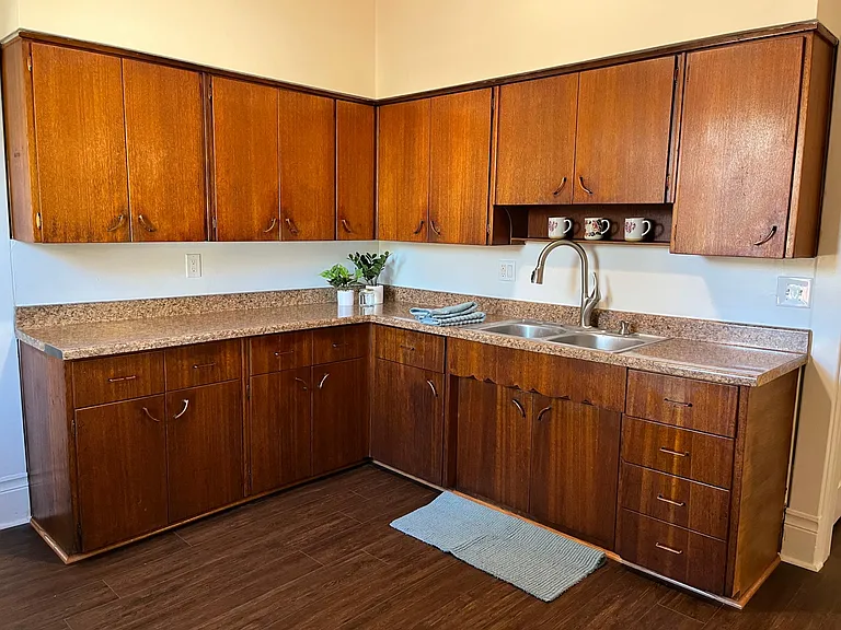 New LVP floors in the kitchen. The original warm wood cabinets and pulls have been refurbished to a beautiful gleam. Loads of counter space and storage in this kitchen, plus an additional giant size pantry (not pictured.)