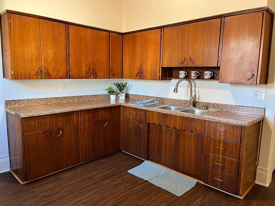 New LVP floors in the kitchen. The original warm wood cabinets and pulls have been refurbished to a beautiful gleam. Loads of counter space and storage in this kitchen, plus an additional giant size pantry (not pictured.)
