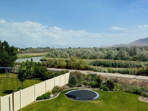All bedrooms have views of the mountains, river, trampoline and basketball court. Jordan River Parkway Trail is directly behind the house