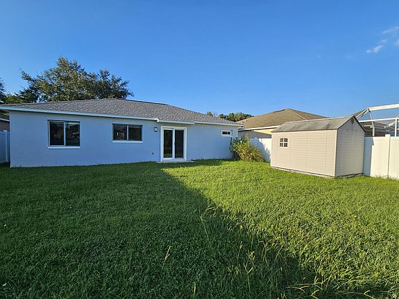 Back of house and backyard with outside storage/shed unit