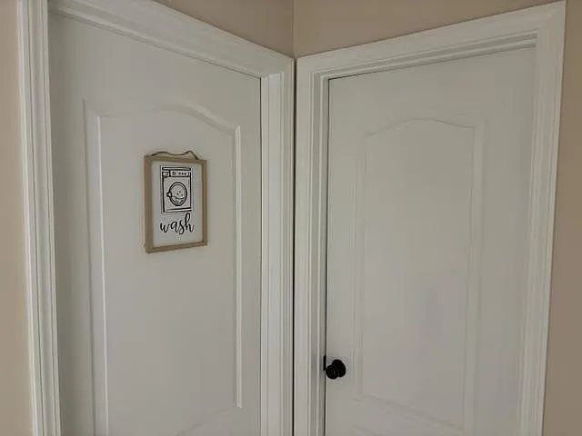 Interior hallway with two paneled doors, including a dedicated laundry area for convenient everyday living.