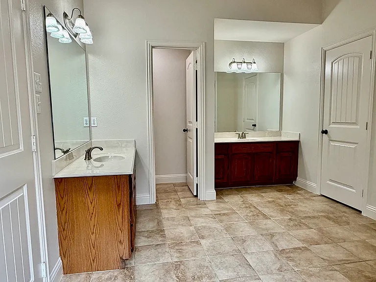 Master bathroom with separate vanities and private potty room