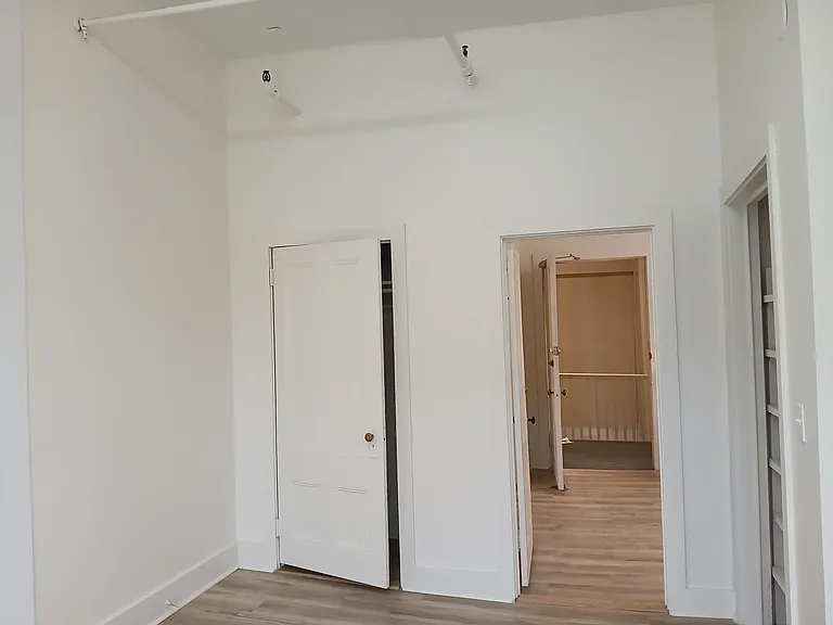 unit renovated in 2025 with new laminate flooring. View from bedroom into kitchen area.